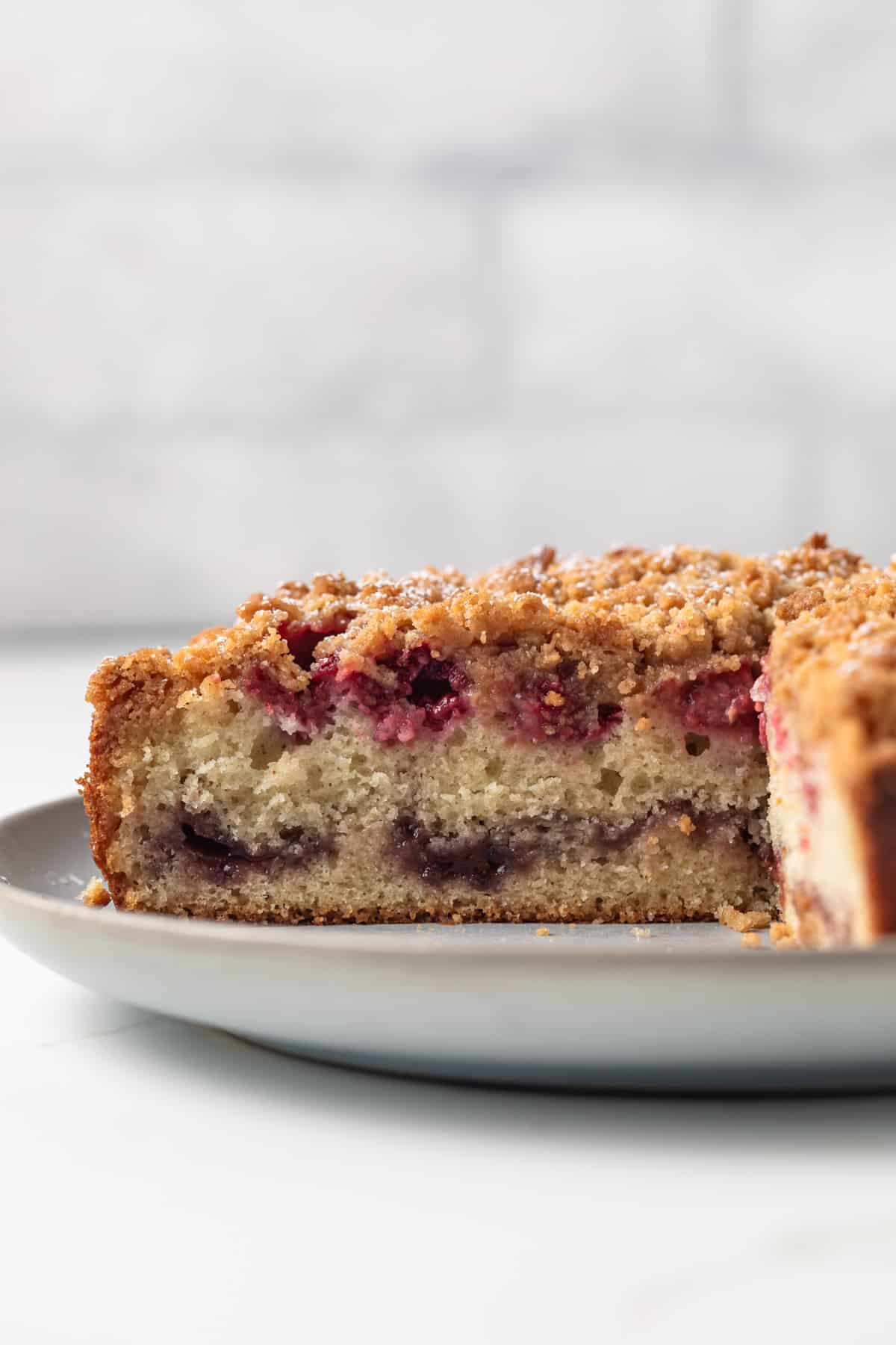 Raspberry coffee cake with a slice taken out so the inside is visible.