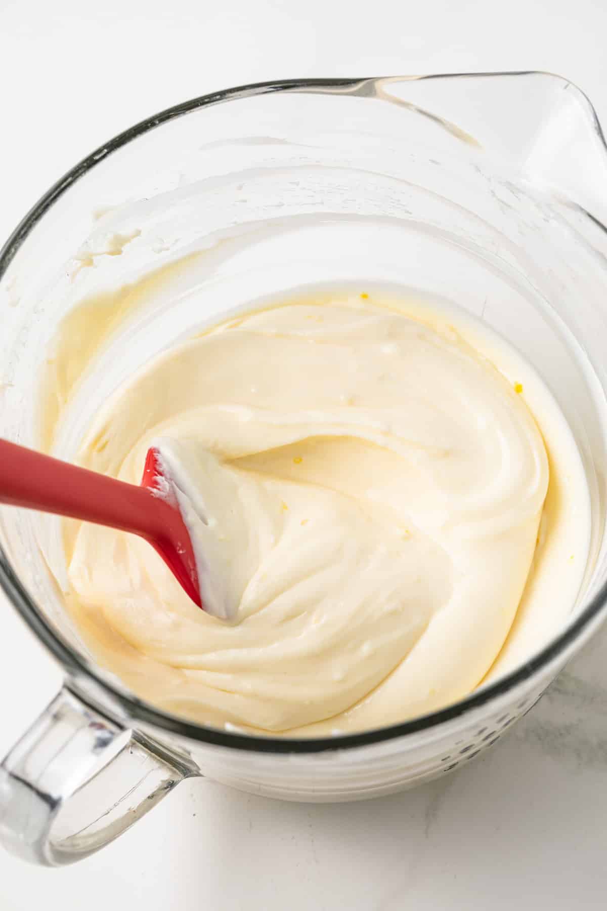Lemon cheesecake filling in glass bowl.
