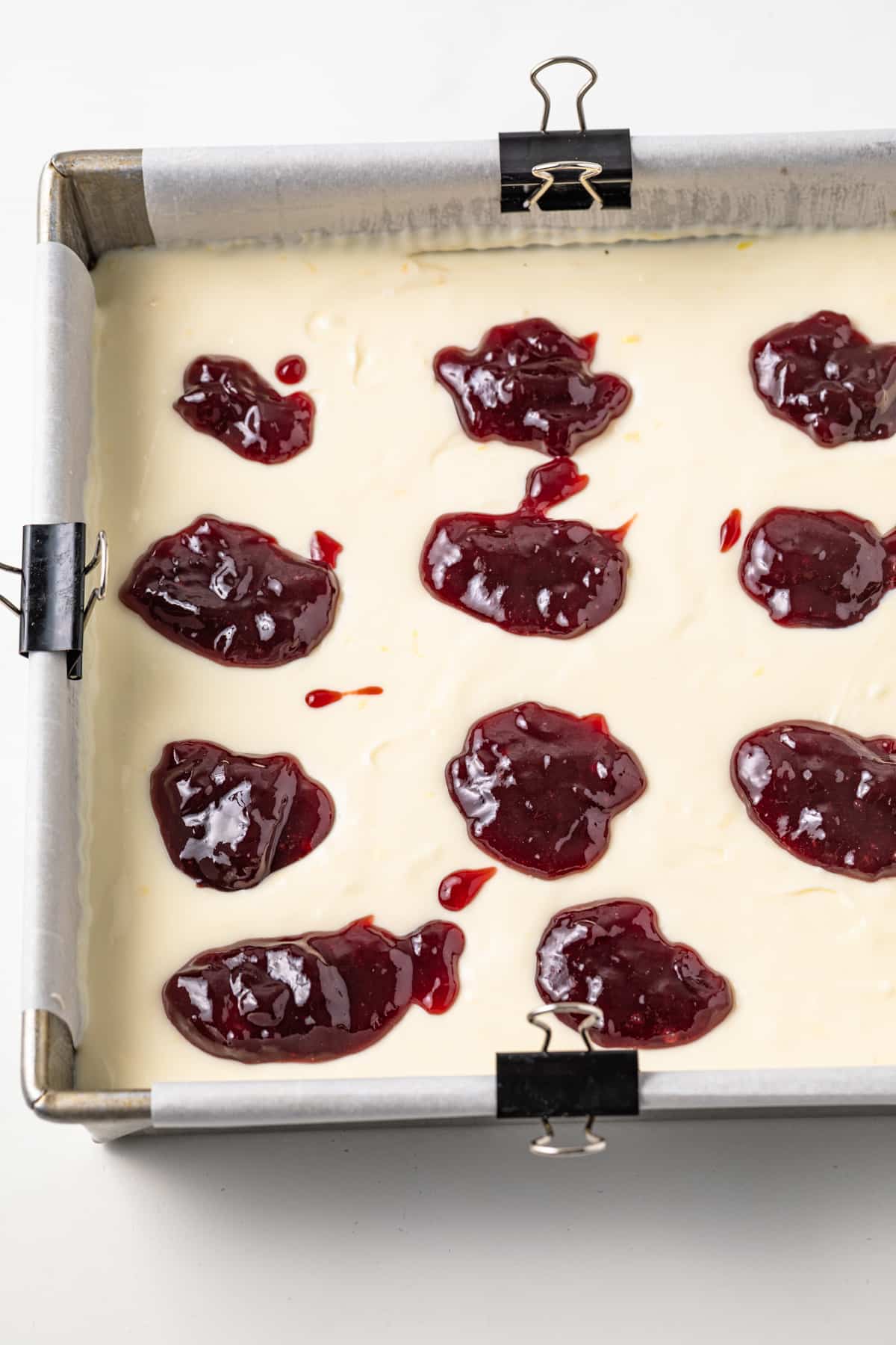 Dollops of raspberry jam over lemon cheesecake filling.