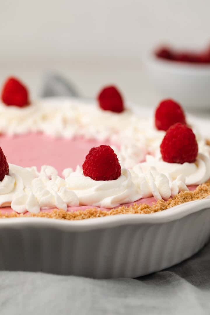 side view of raspberry pie in white pie dish