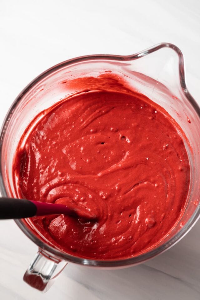 Red velvet cake batter in a glass bowl.