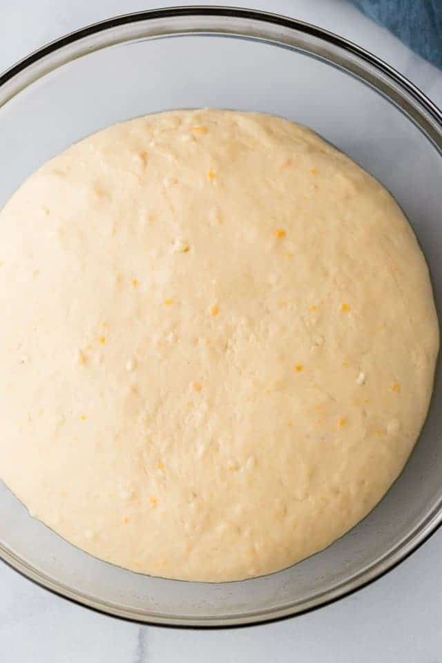 risen yeast dough in glass bowl