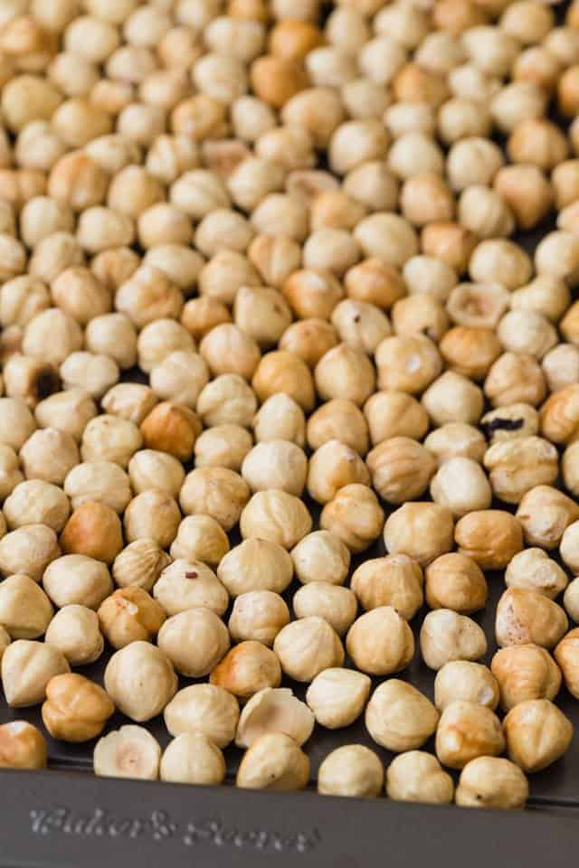 Roasted hazelnuts on a baking sheet.