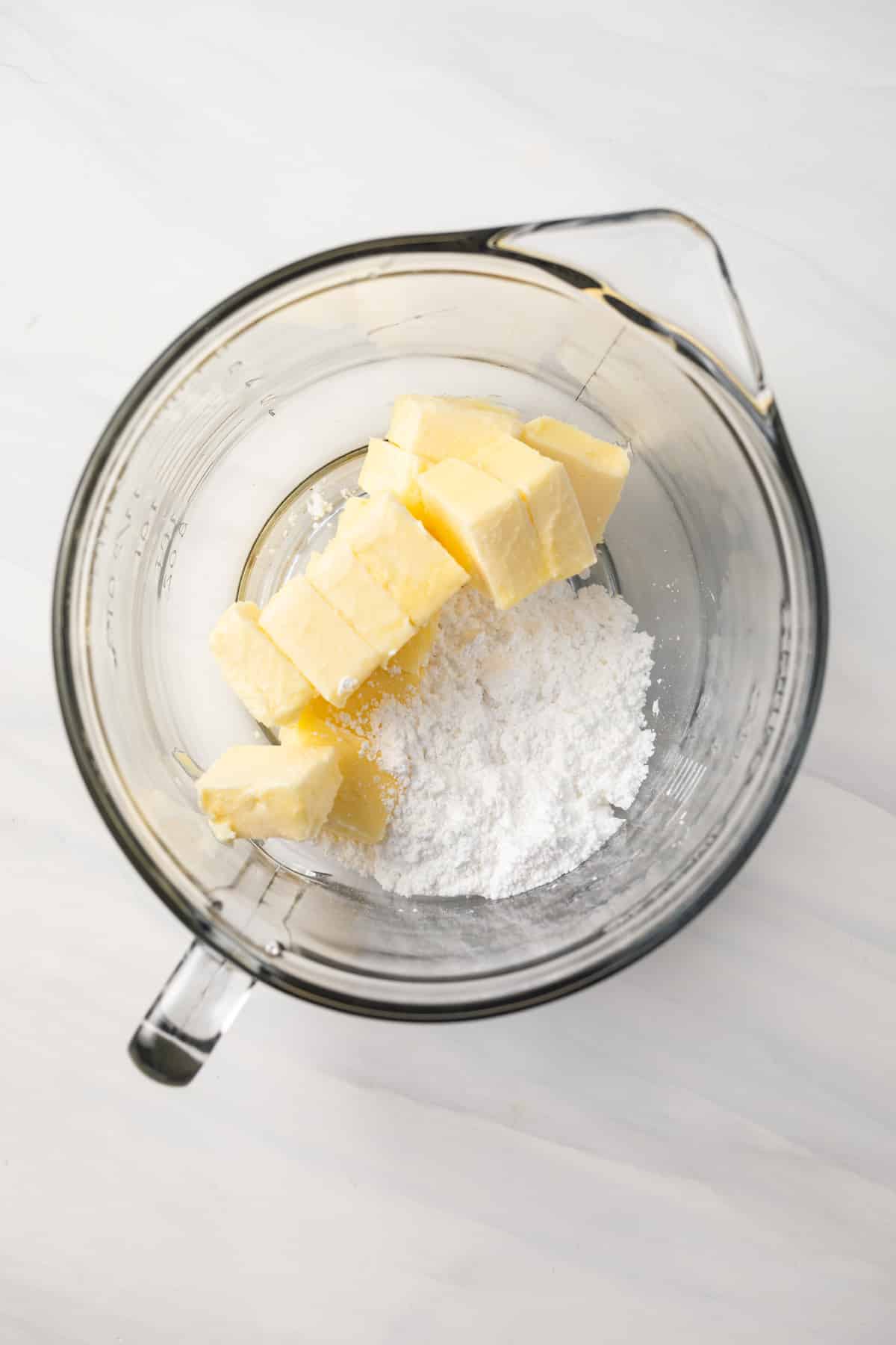 Butter and powdered sugar in glass bowl