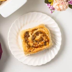 Overhead of sausage and cheese breakfast roll on plate.