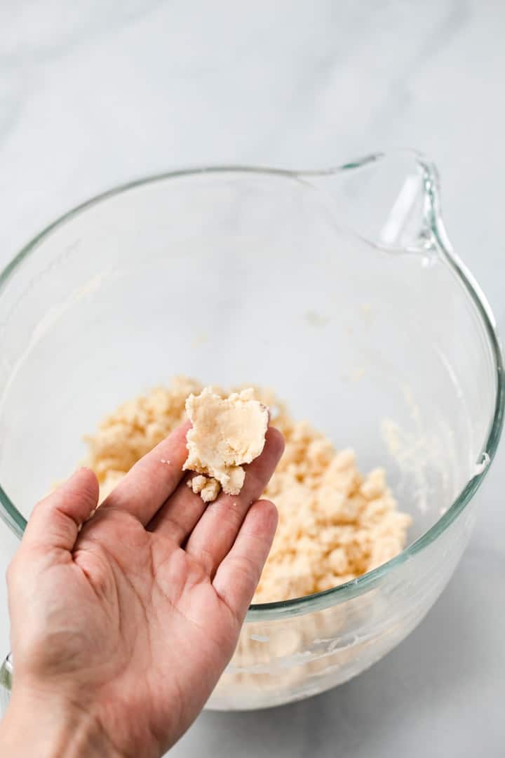 hand holding shortbread cookie dough to show correct texture