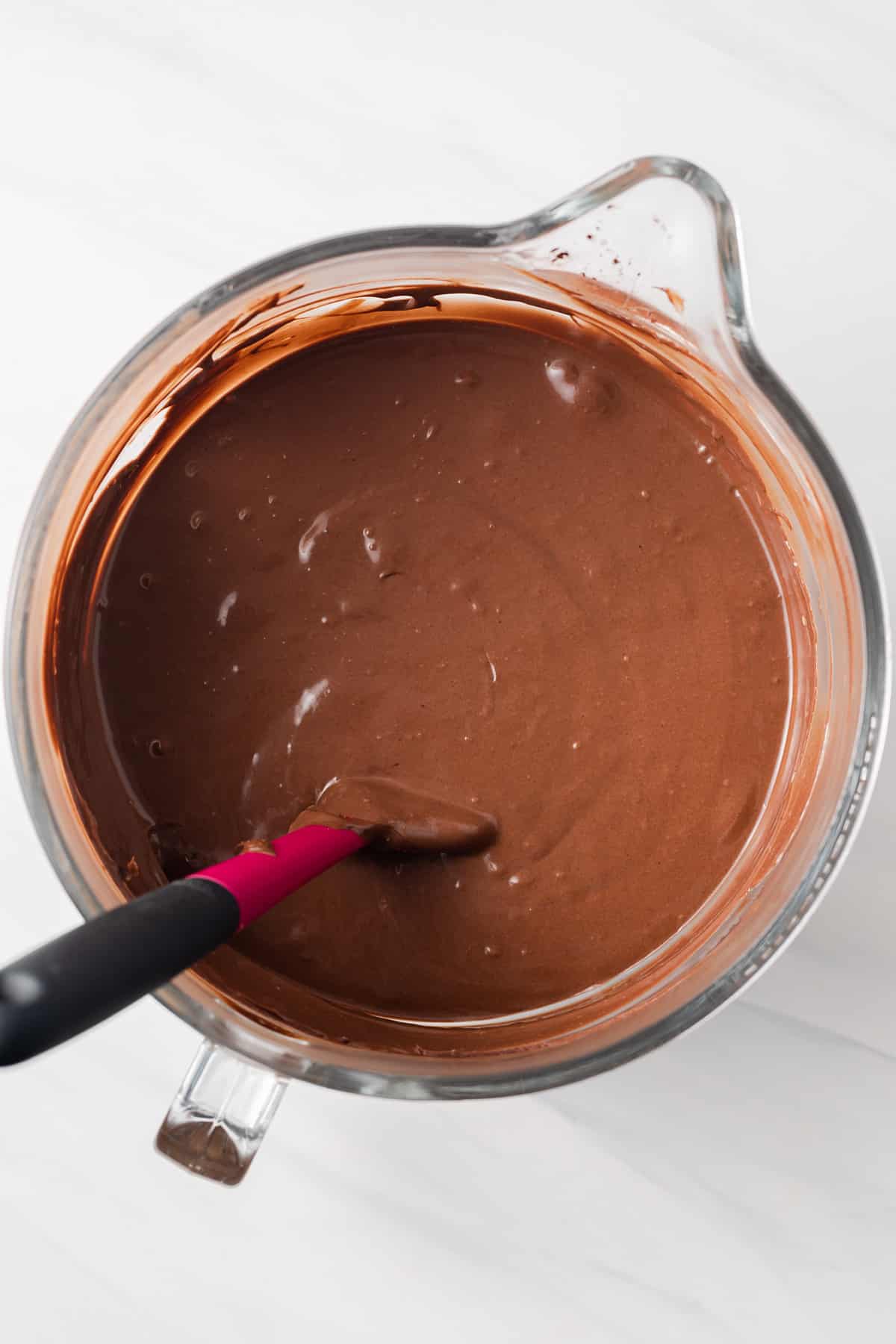 Chocolate cheesecake batter in glass bowl.