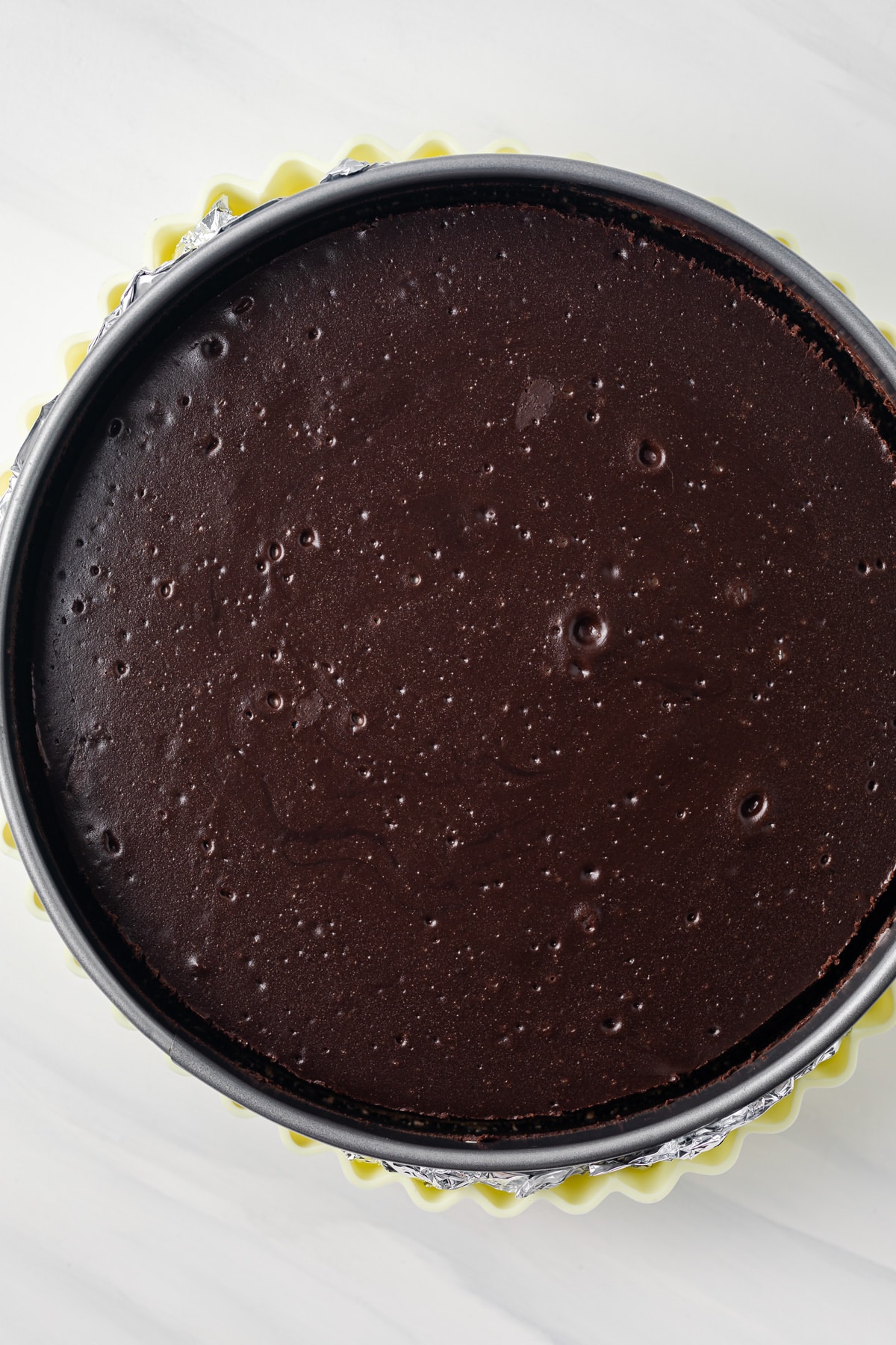 Chocolate cheesecake in baking pan.