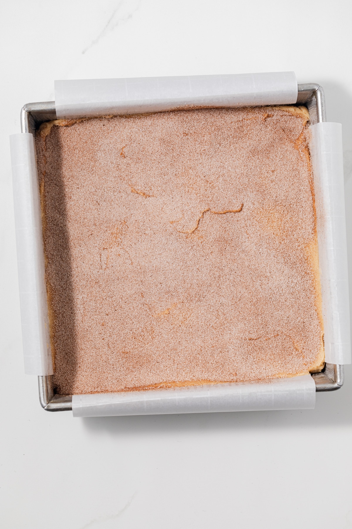 Unbaked blondies topped with cinnamon sugar.