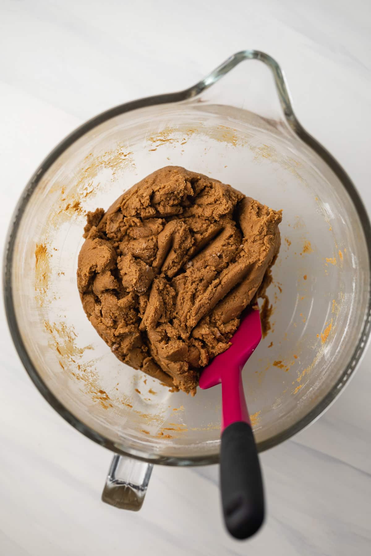Molasses cookie dough in glass bowl.