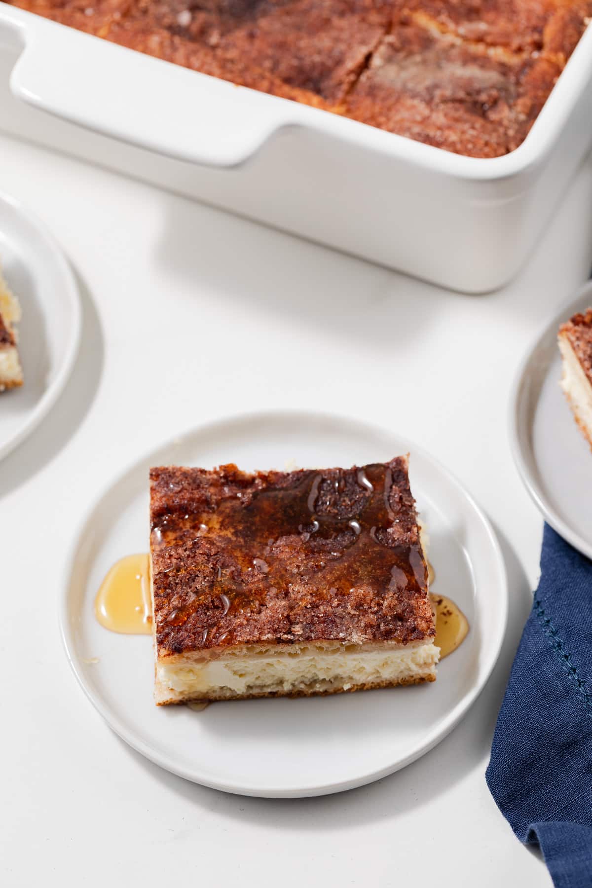 Angled view of slice of sopapilla cheesecake on white plate.