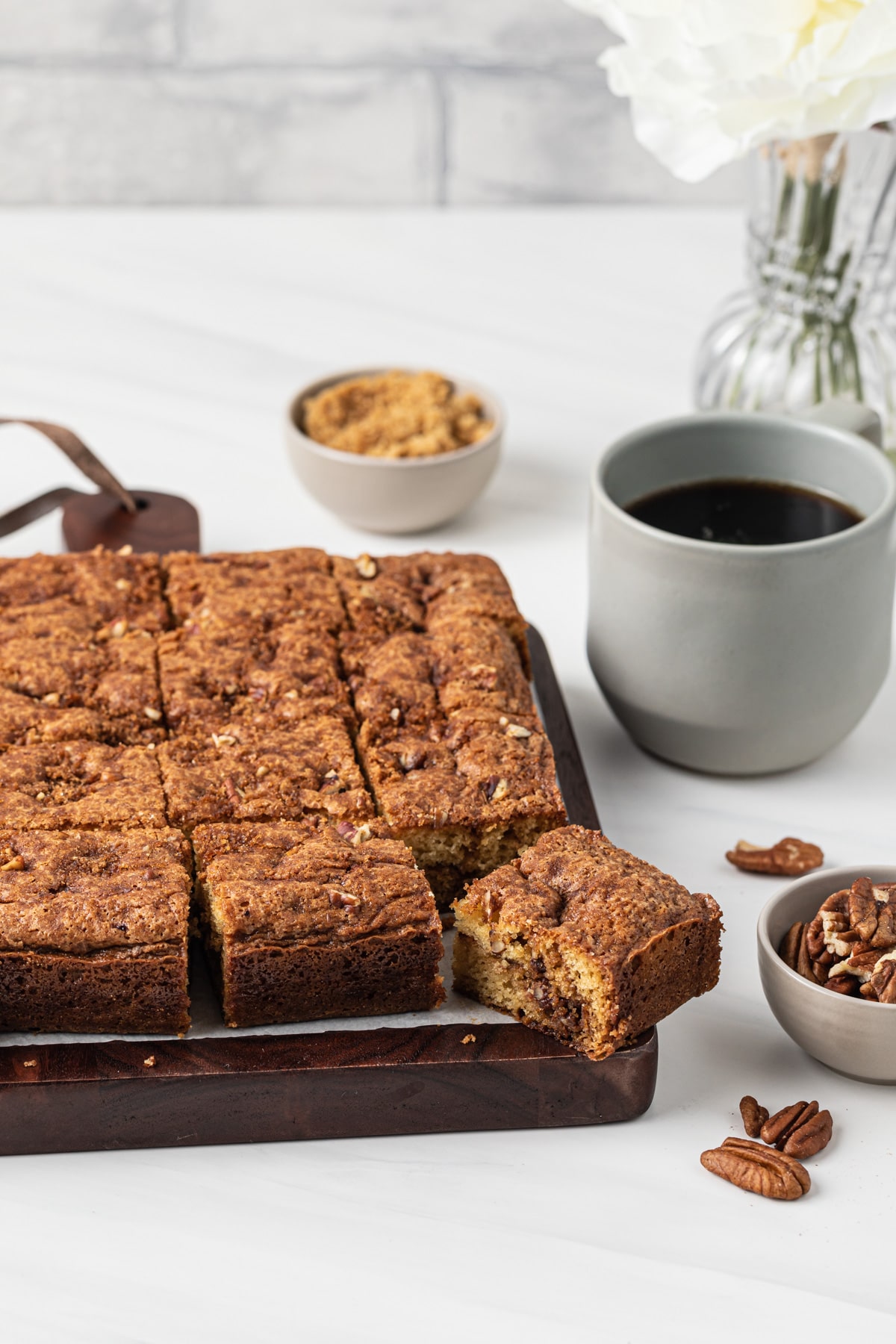 sliced coffee cake on wooden board with cup of coffee