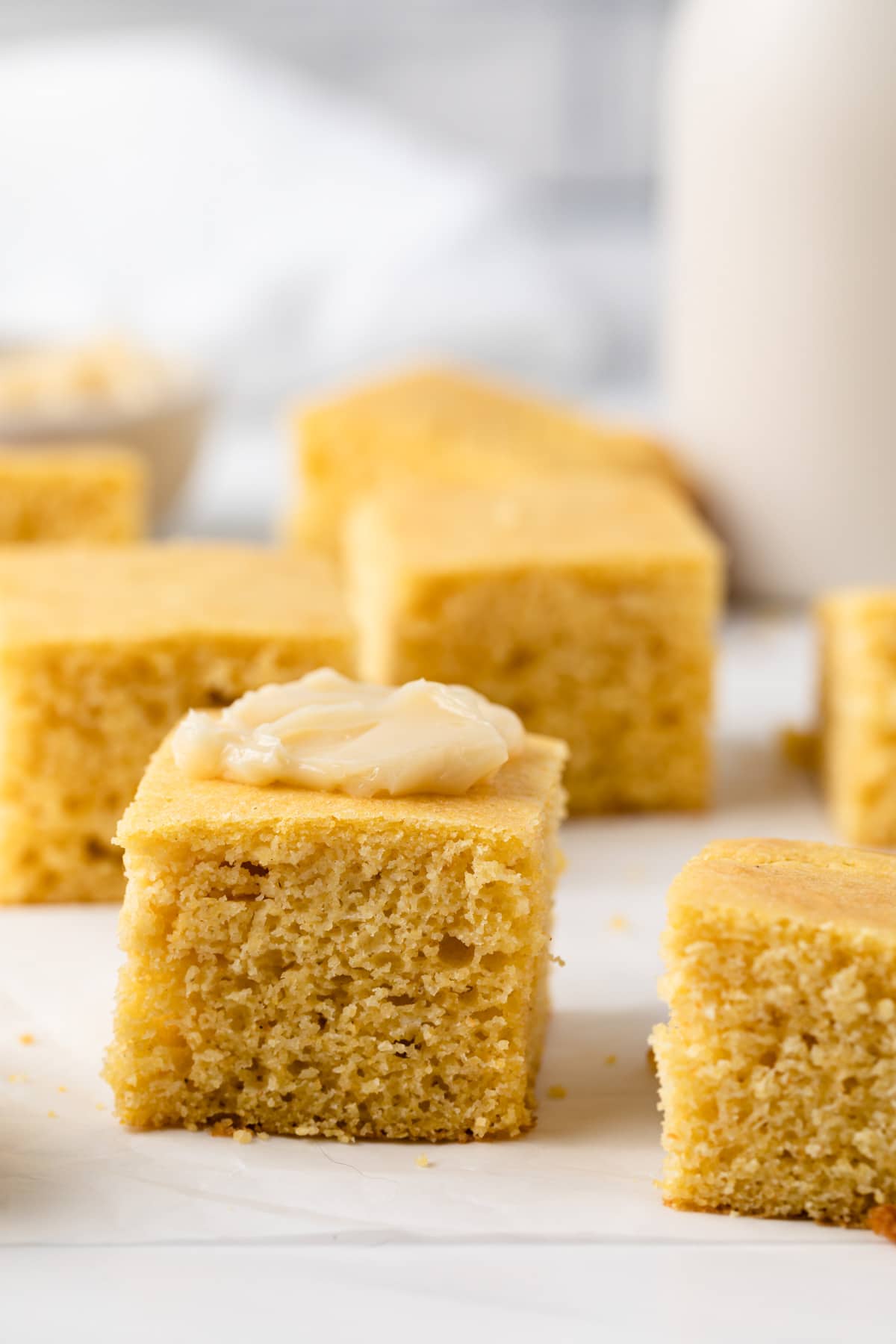 front view of southern cornbread squares with butter smeared on top of one