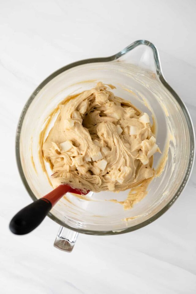 Chopped pears being stirred into quick bread batter