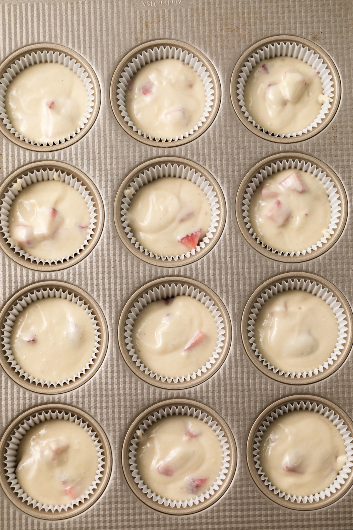 Strawberry cupcake batter in muffin pan.