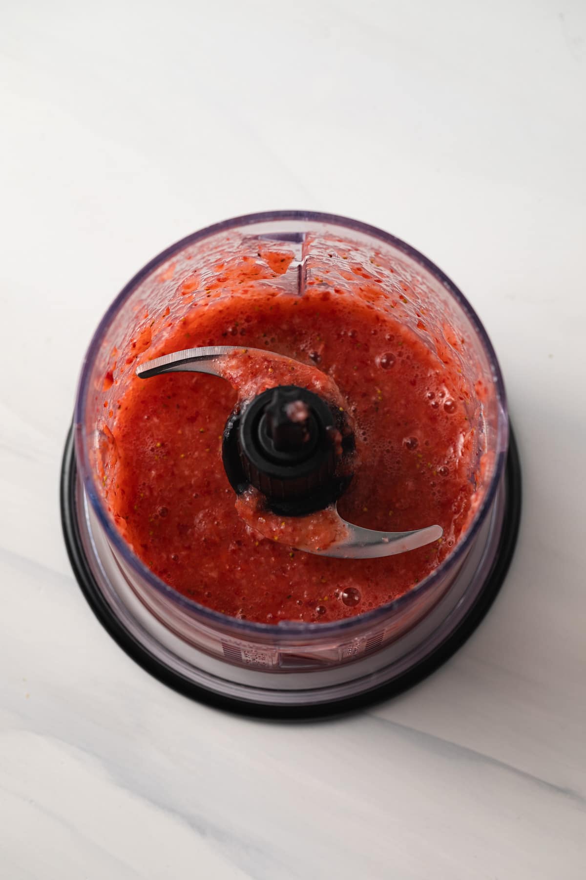 Pureed strawberries in a food processor.