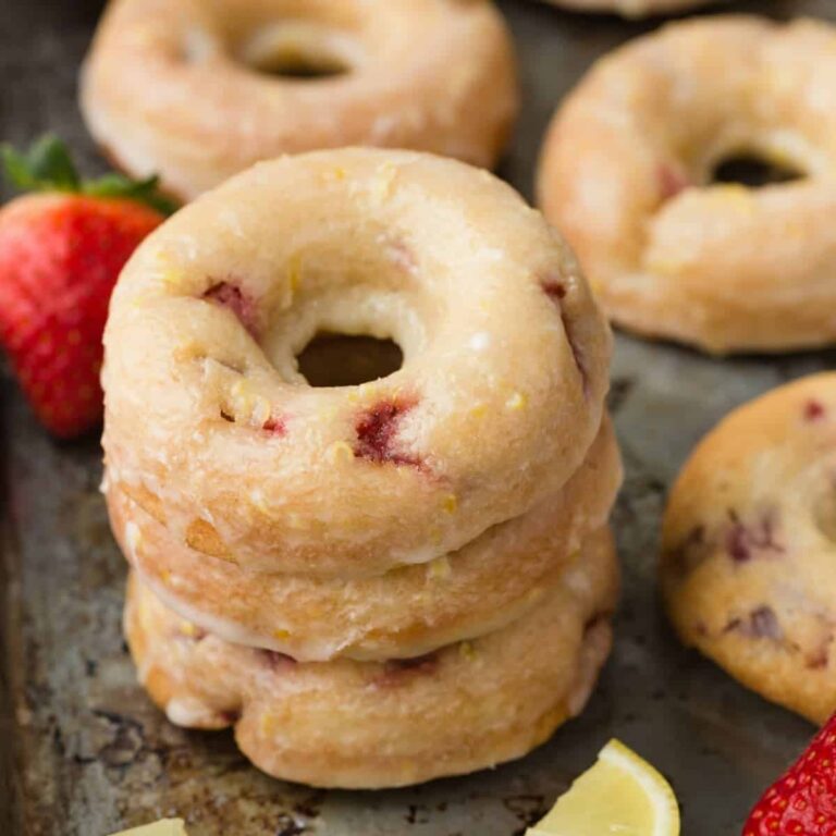 Strawberry Donuts with Lemon Glaze stacked on a baking sheet