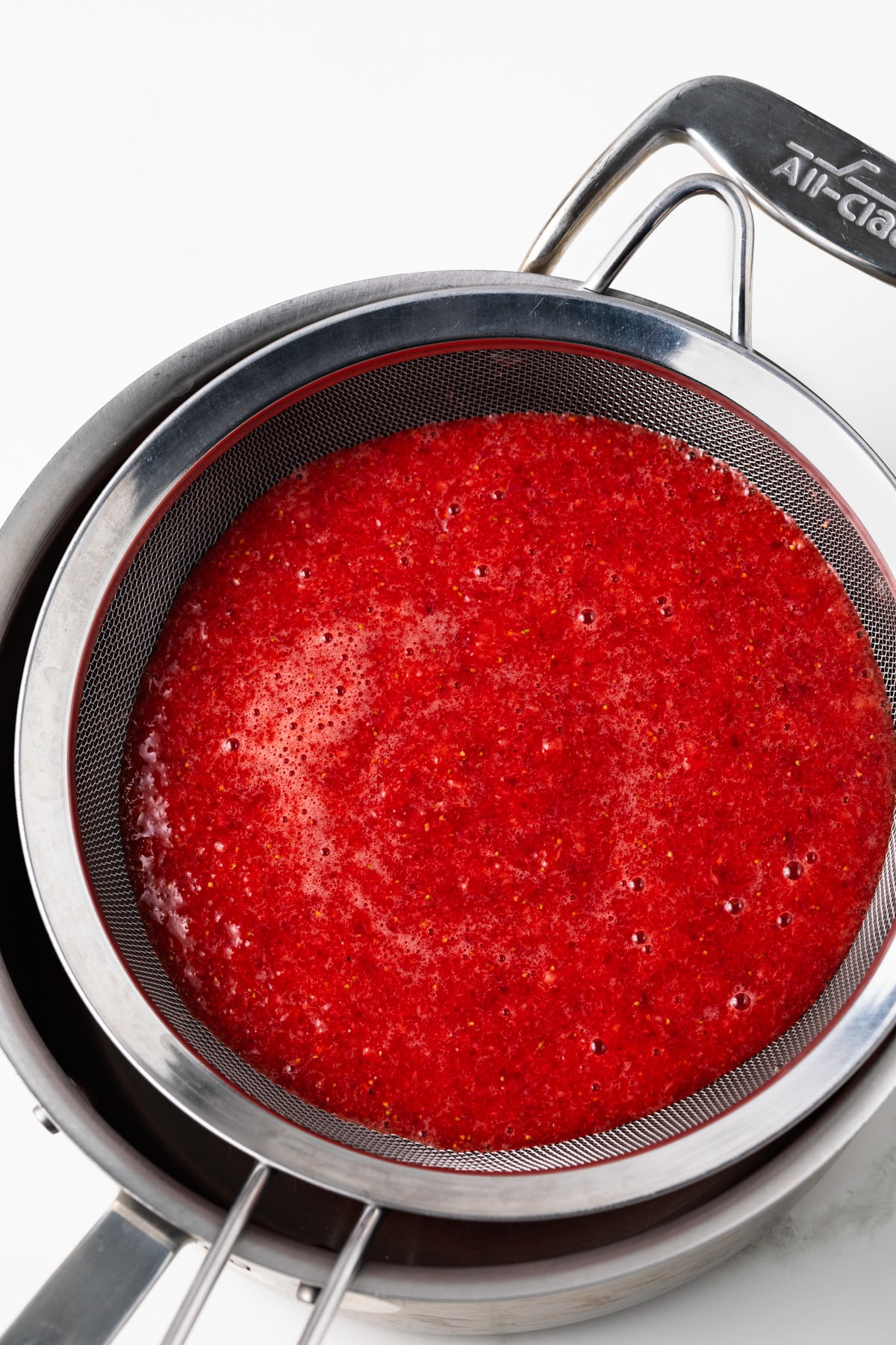 Strawberry puree in a sieve.