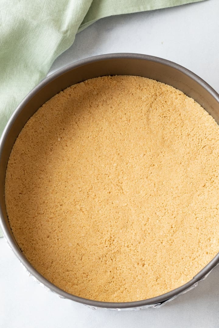 Golden Oreo crumbs pressed in the bottom of round pan
