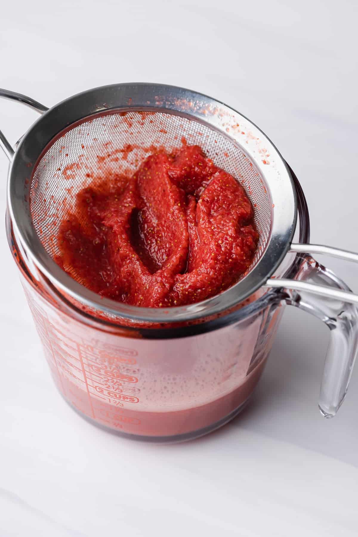 strawberry puree added to milk and gelatin in a pot