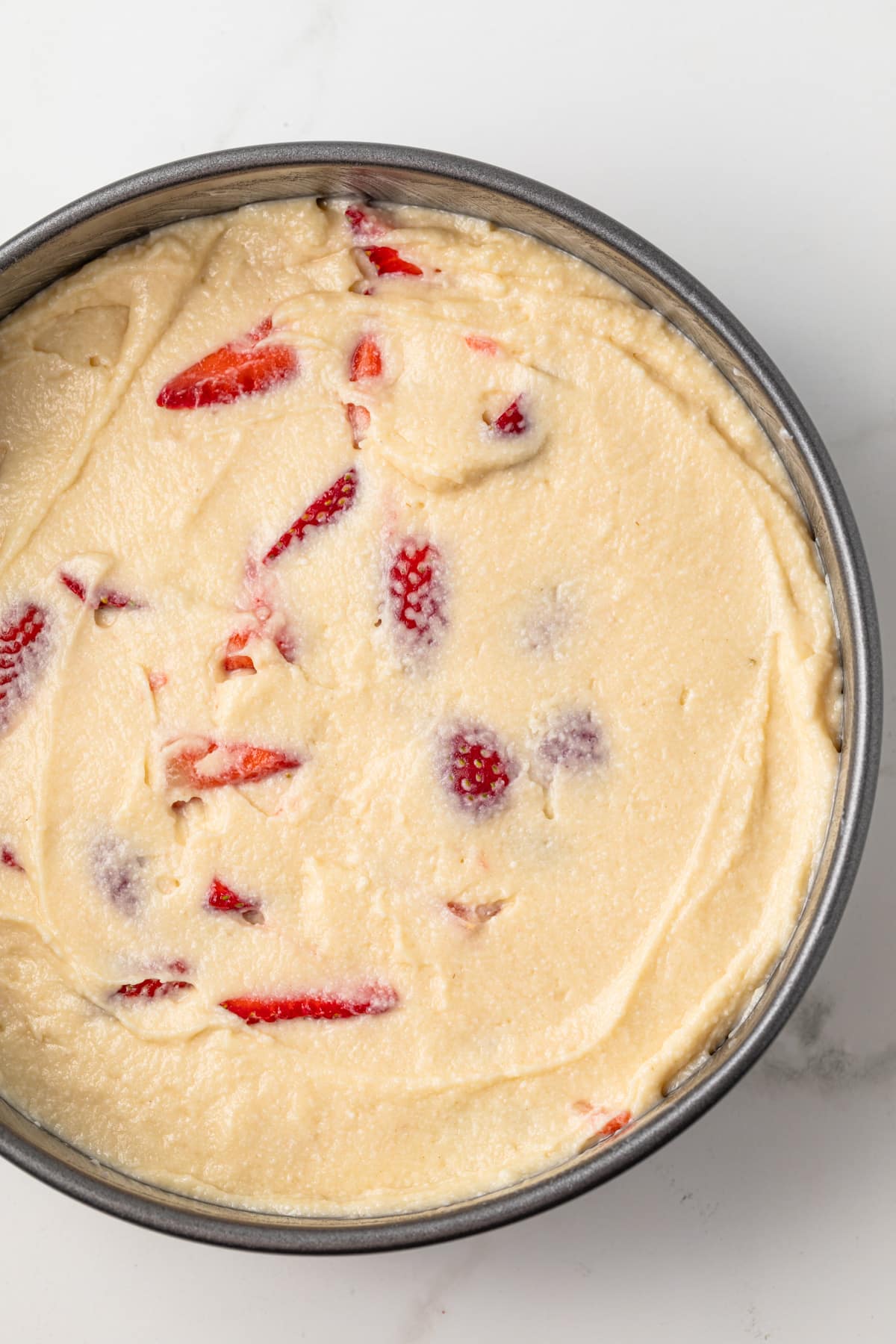 Cake batter in round cake pan.