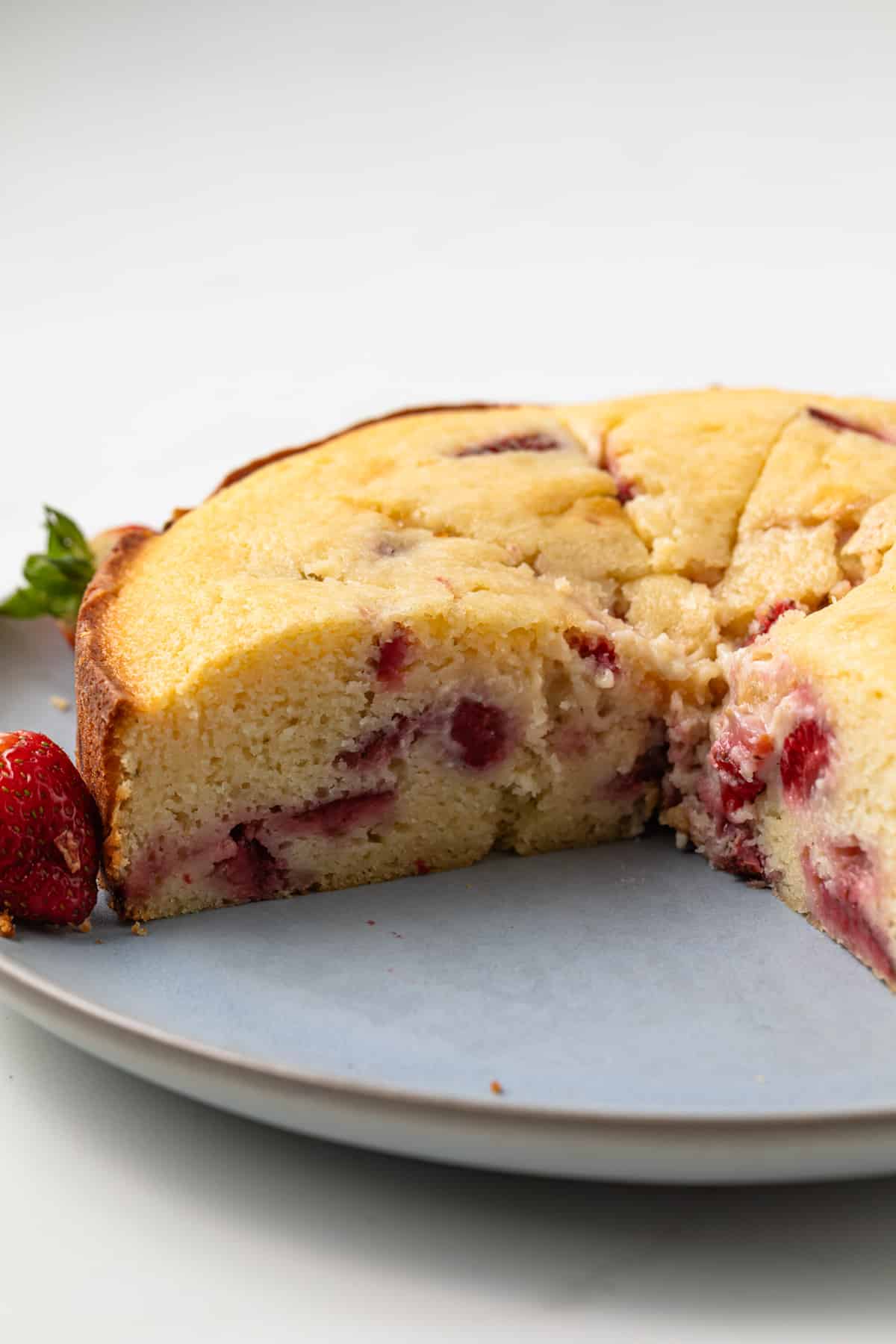 Sliced strawberry ricotta cake on plate.