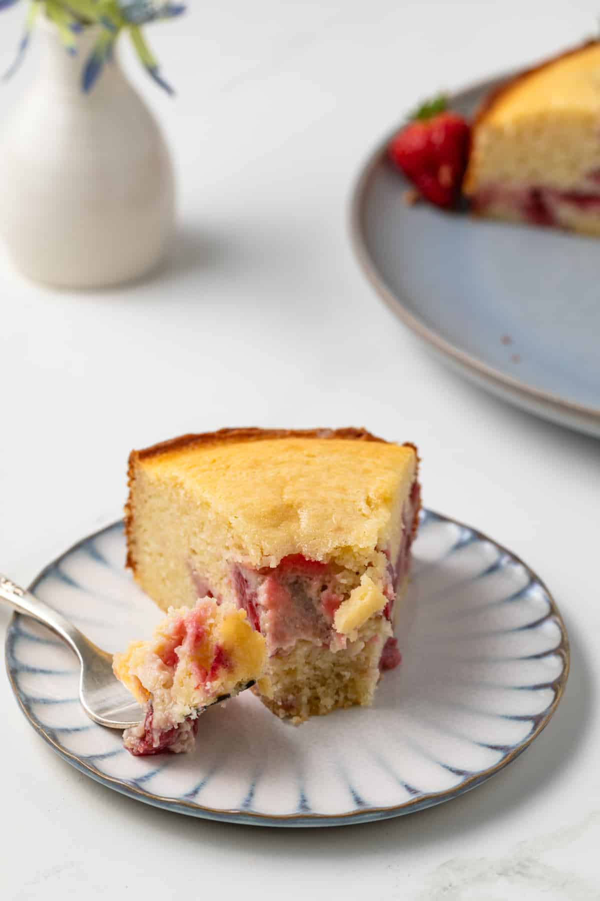 Slice of strawberry ricotta cake with bite taken out.