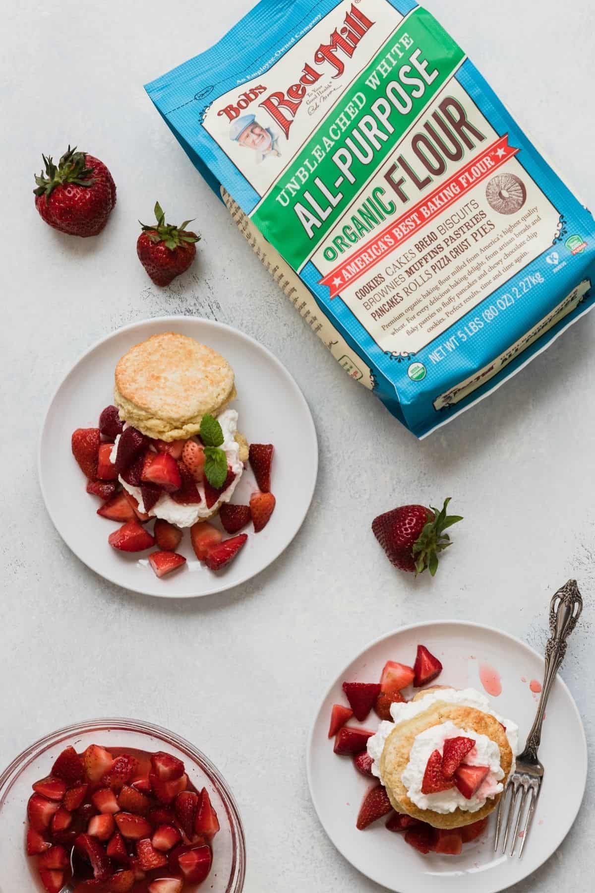 overhead of strawberry shortcakes on plates with Bob's Red Mill Flour