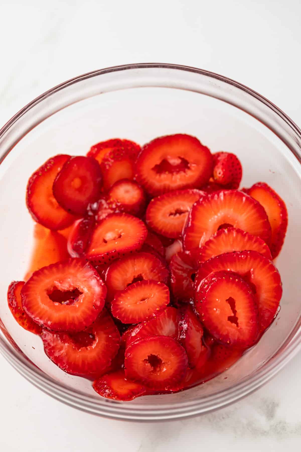 Macerated strawberries in glass bowl.