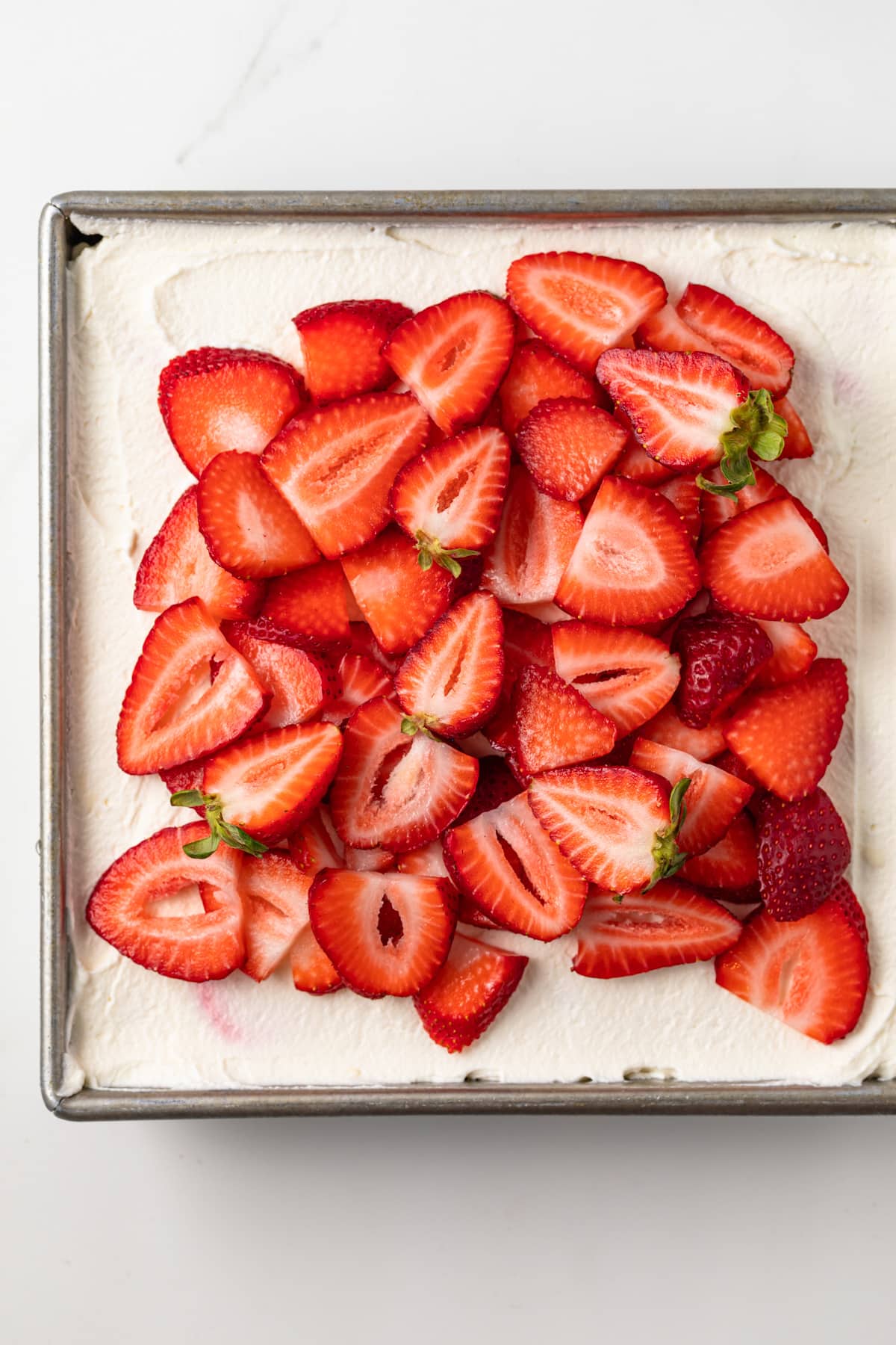 Overhead of strawberry tiramisu in metal pan.