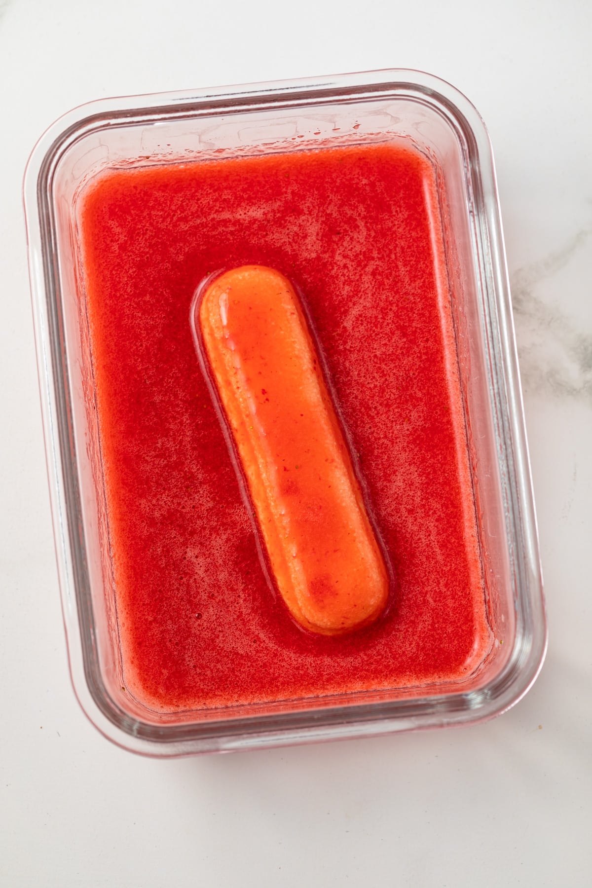 Ladyfinger cookie dipped in strawberry juice.