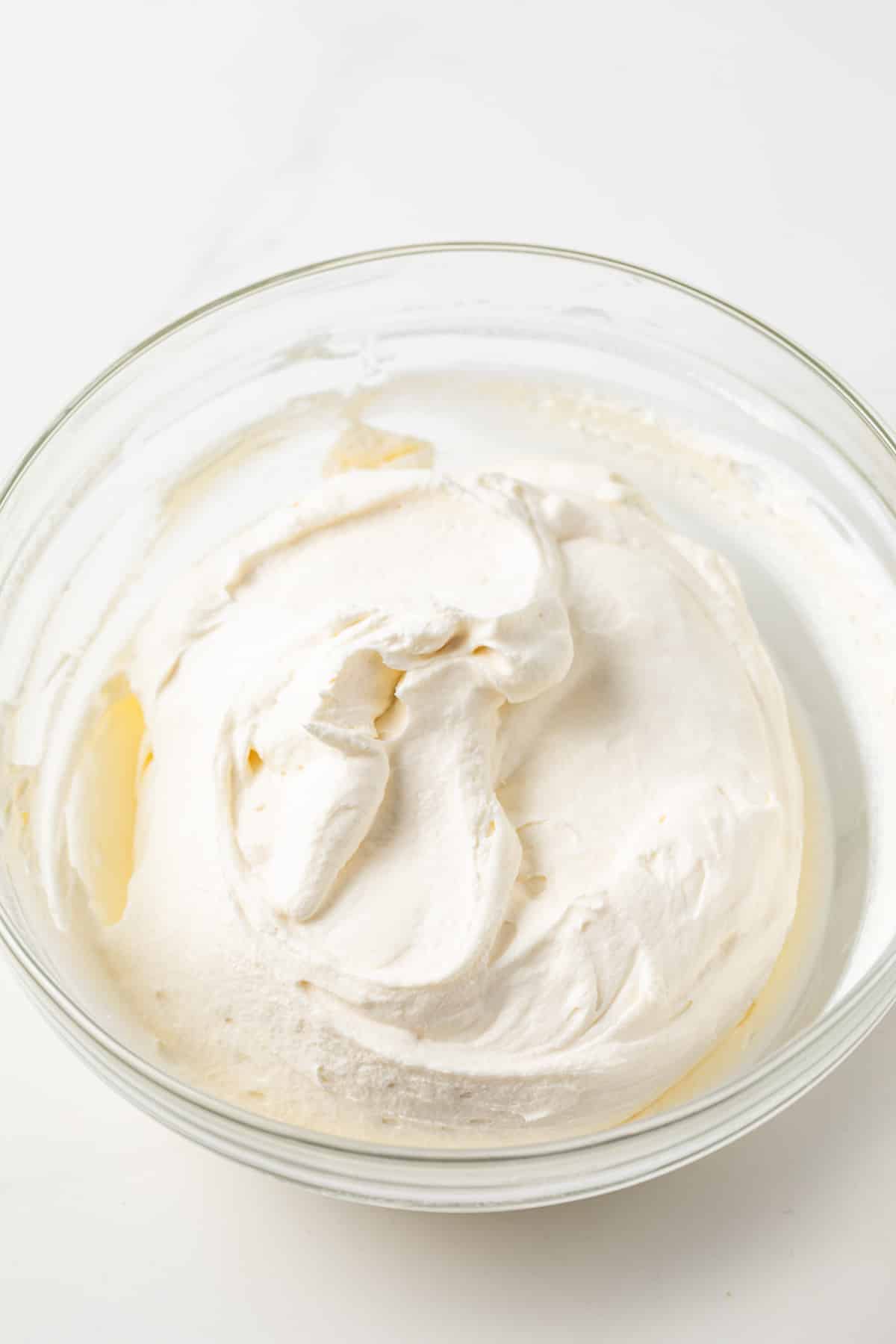 Whipped mascarpone cream in glass bowl.