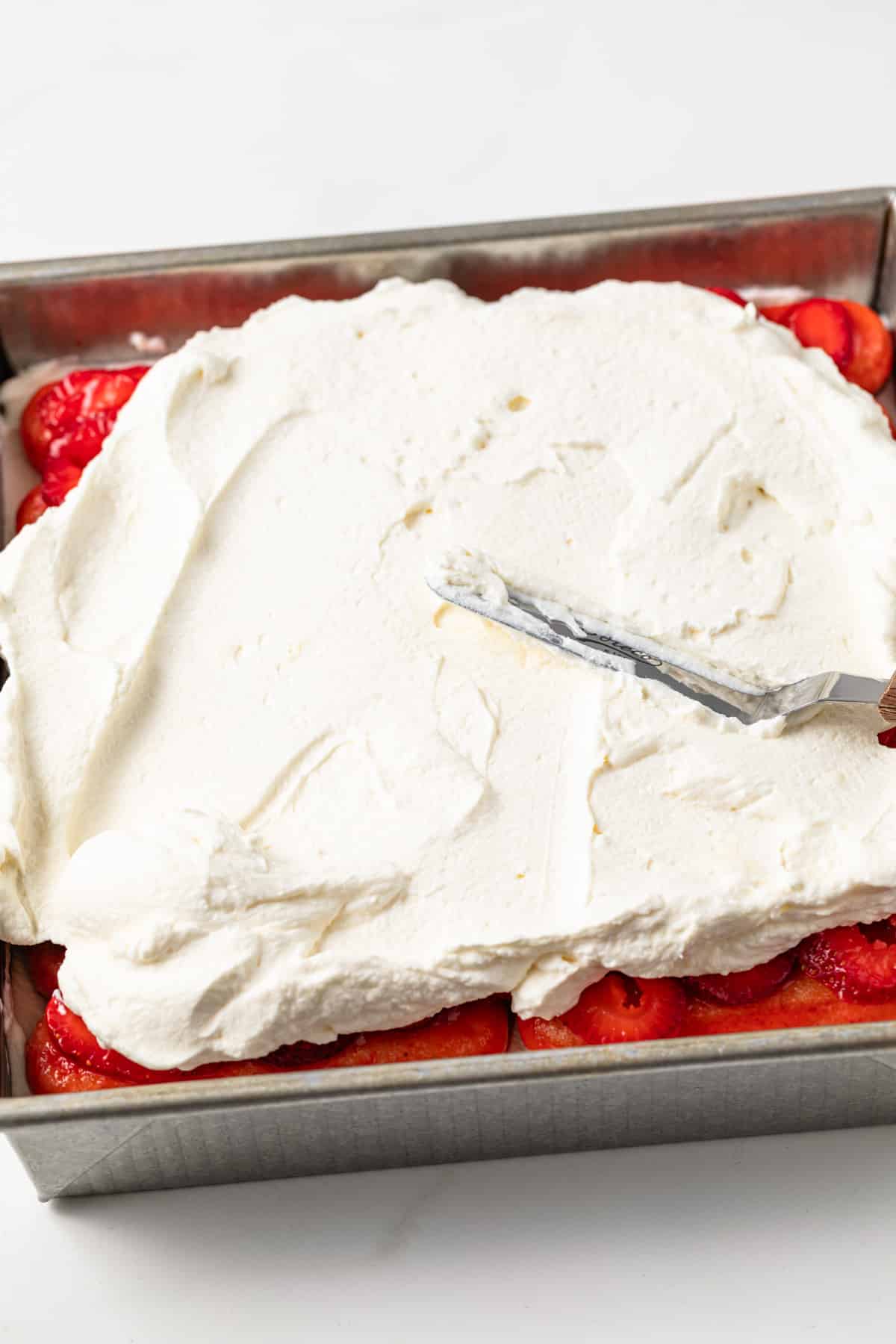 Whipped mascarpone cream spread over strawberries.