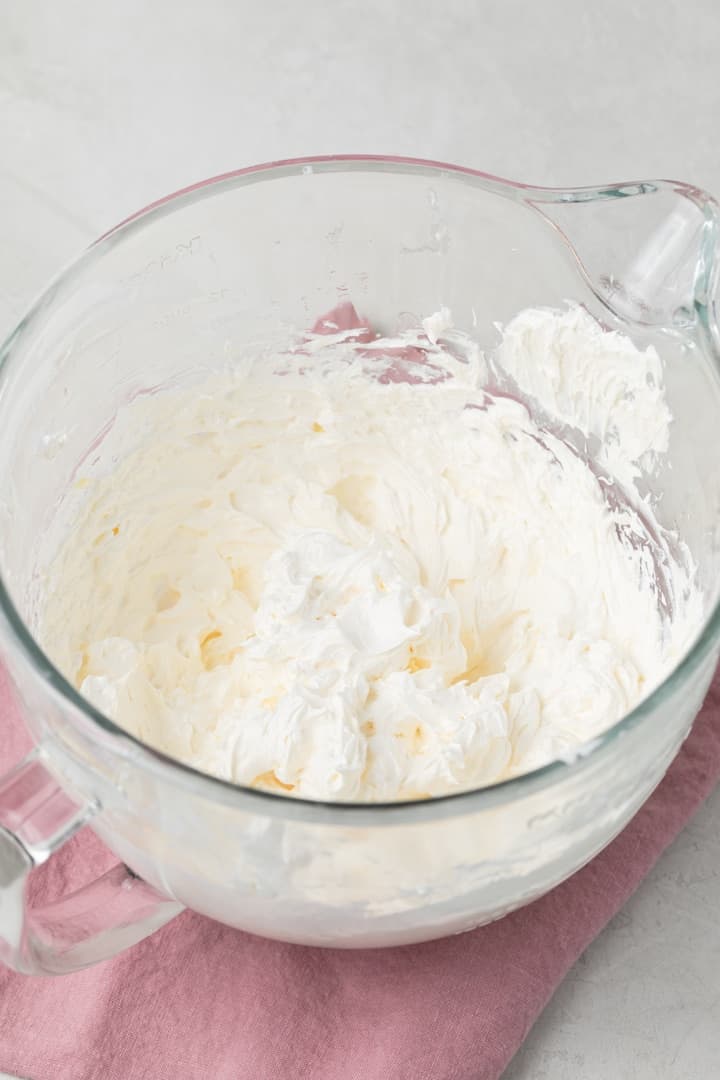 whipped swiss buttercream frosting in a glass bowl