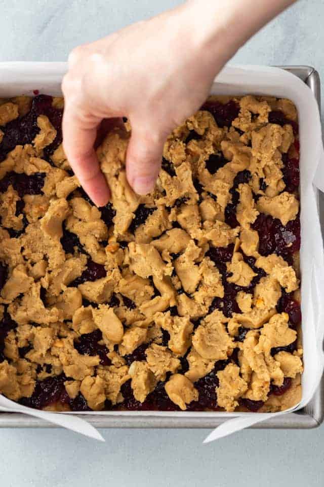 Topping sprinkled over the jelly and peanut butter base in a square pan.