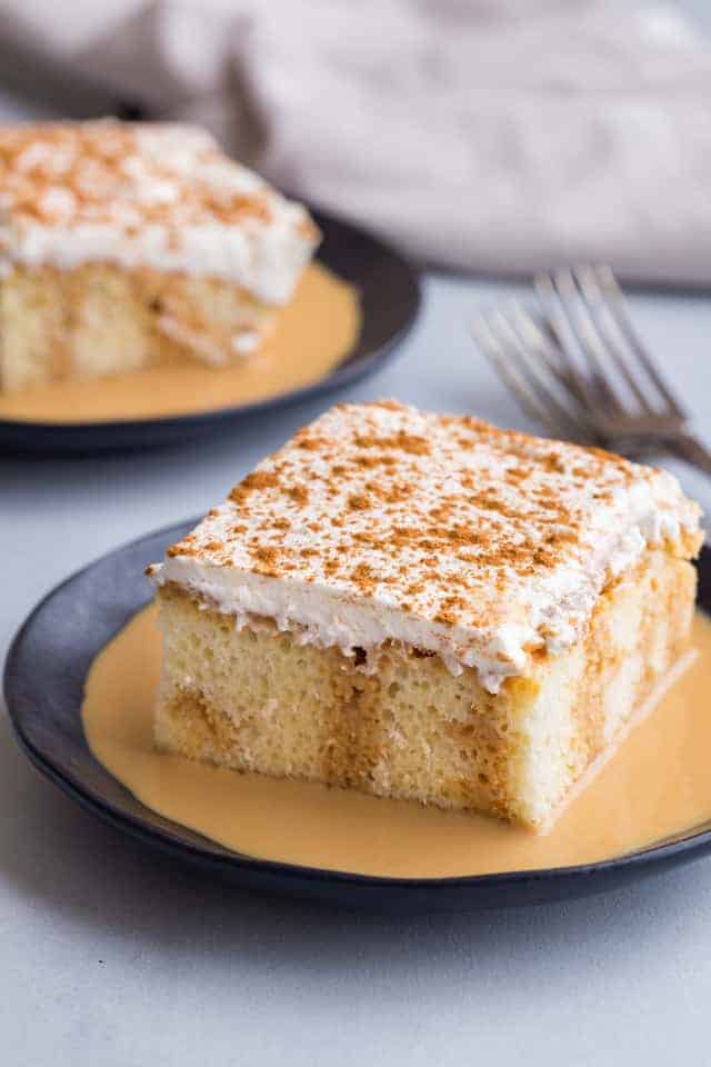 side view of tres leches cake on a dark blue plate