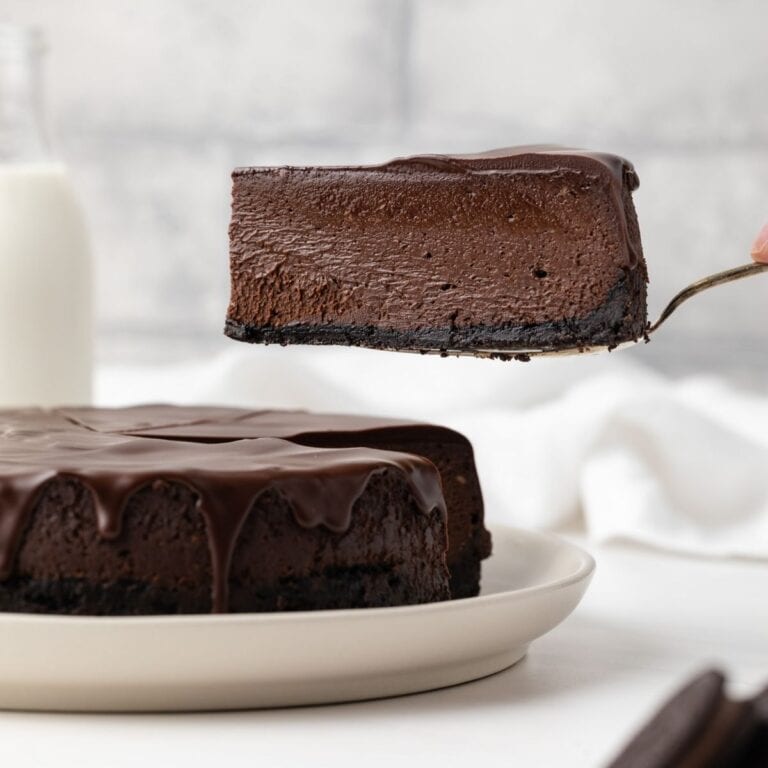 Side view of triple chocolate cheesecake on a white plate.