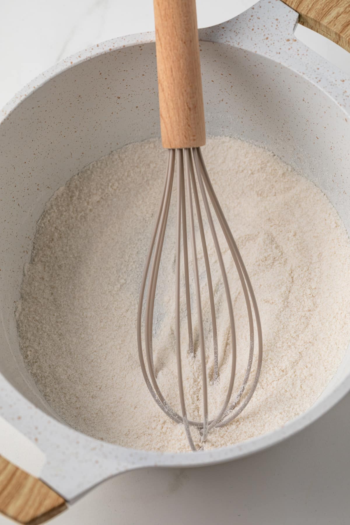 Flour, sugar, and salt whisked in a saucepan.
