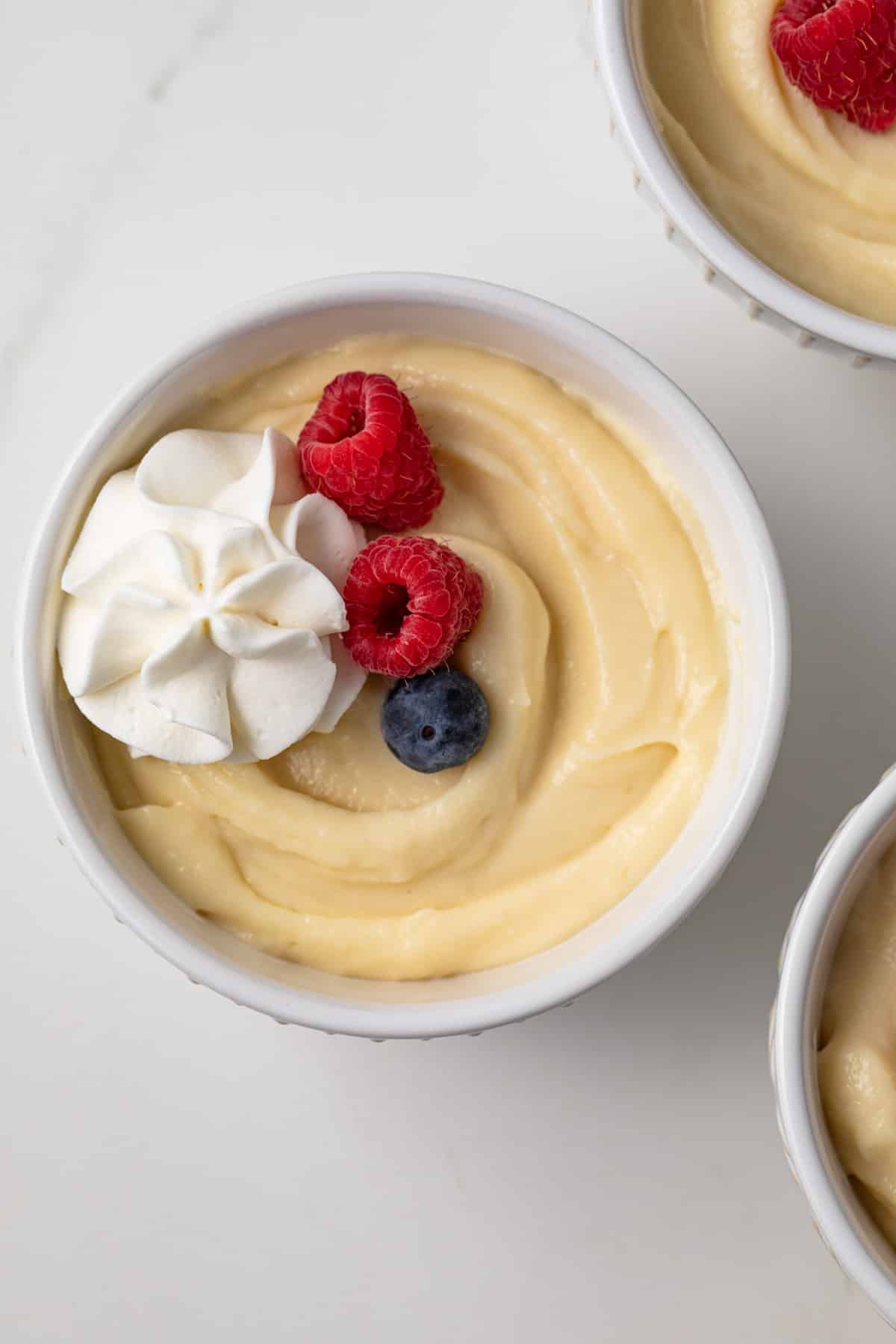 Overhead of vanilla pudding in white bowl.