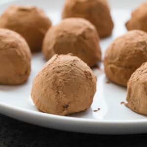Vegan chocolate truffles neatly arranged on a white plate.