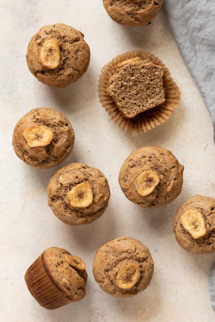 whole wheat banana muffins scattered on tabletop
