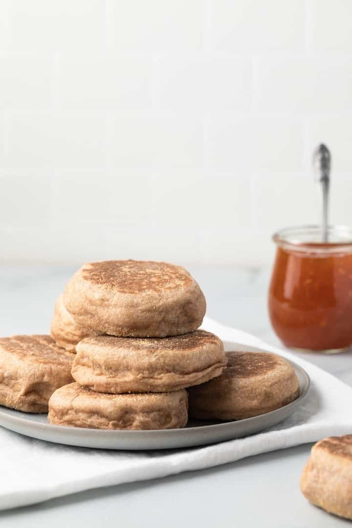 side view of whole wheat English Muffins on grey plate