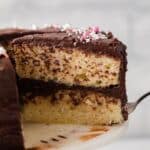 Slice of yellow cake being pulled away with cake server.