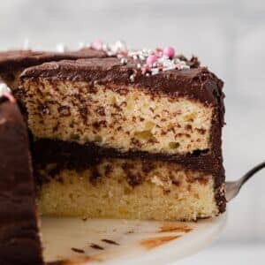 Slice of yellow cake being pulled away with cake server.