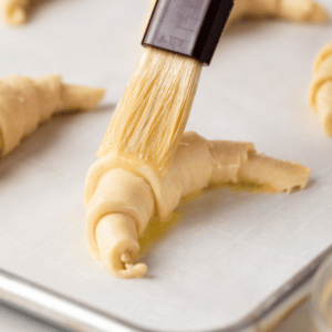Egg wash brushed over crescent roll.
