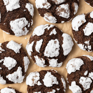 Overhead of chocolate crinkle cookies on parchment paper.
